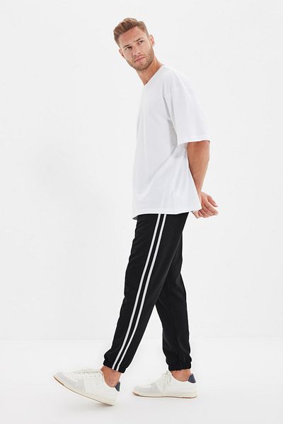 Trendyol Collection Schwarze, reguläre/normal geschnittene, gestreifte Jogginghose mit Reißverschlusstaschen und elastischen Beinen TMNSS20EA0050