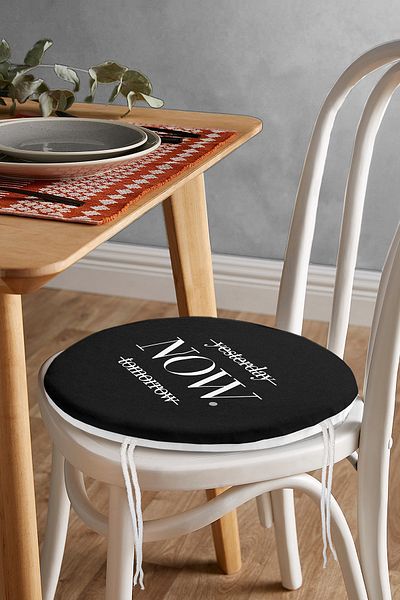Realhomes Modern Round Zippered Chair Cushion with Now Writing on Black Background