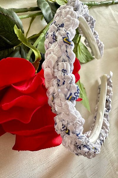 alsaccessories Coroana din satin de culoare albă este realizată cu fire de culoare albă și albastră care se încrucișează.