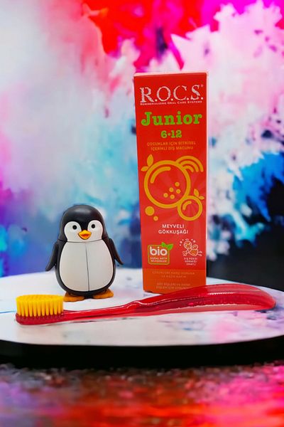 R.O.C.S. R.o.c.s 6-12 مجموعة العناية بالبطريق - معجون أسنان قوس قزح + فرشاة أسنان جونيور حمراء + حاوية البطريق