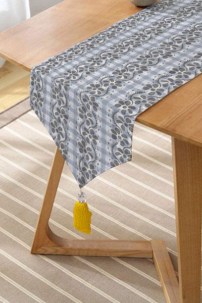 Realhomes Alergăre triunghiular de chenille cu motiv decorativ de flori și ciucuri cu fundal denim