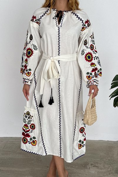 Women's embroidered dress with tassel waist belt and embroidered detailing.