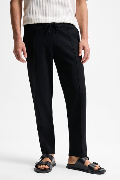Bogarde men's black relaxed fit sweatpants with elastic waistband, drawstring, side pockets, and ribbed front.