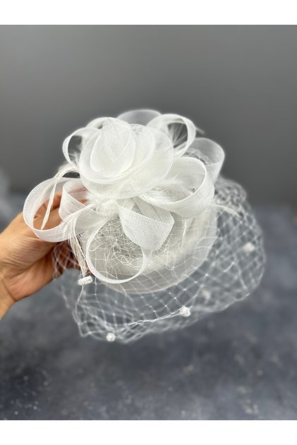 Simple yet elegant bridal wedding hat with pearl and feather details, specially designed.