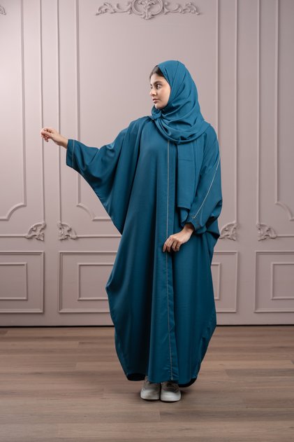 عباية لافينيا الشبابية، على شكل بشت فيروزي، مع حواف ذهبية على الجهة الأمامية والأكمام.