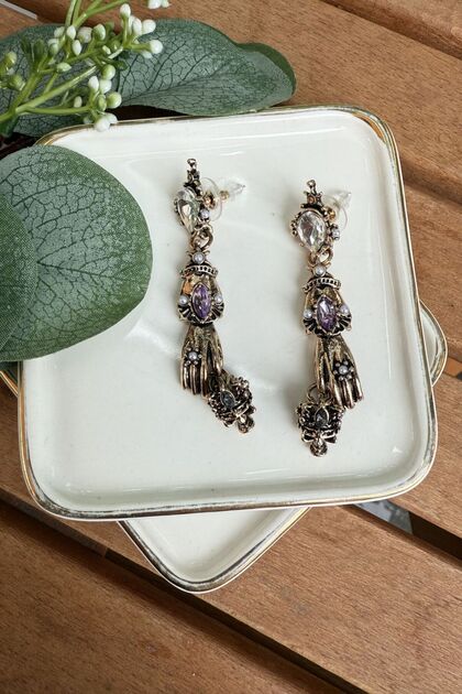 Zr Model Antique Skull Holding Earrings