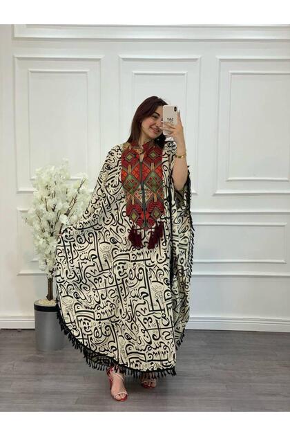 Butterfly caftan from Layali Al Jalabiya - featuring Arabic calligraphy, colorful traditional embroidery, and tassels.