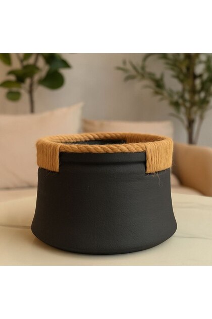 A luxurious work of art featuring a black earthenware pot adorned with jute rope.