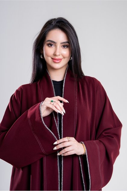 A charming winter abaya in burgundy, made of royal crepe fabric with a touch of silver-grey beading.