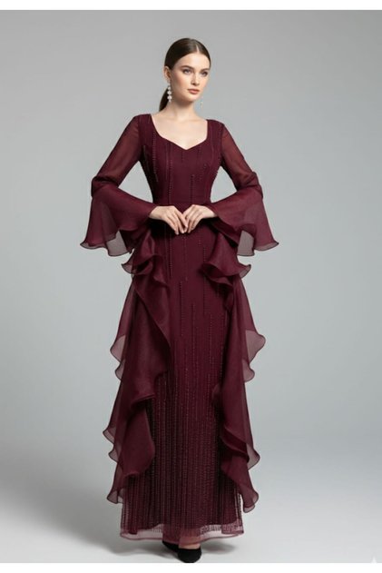 An elegant evening dress in a deep burgundy color, featuring a sophisticated design that combines softness and luxury.