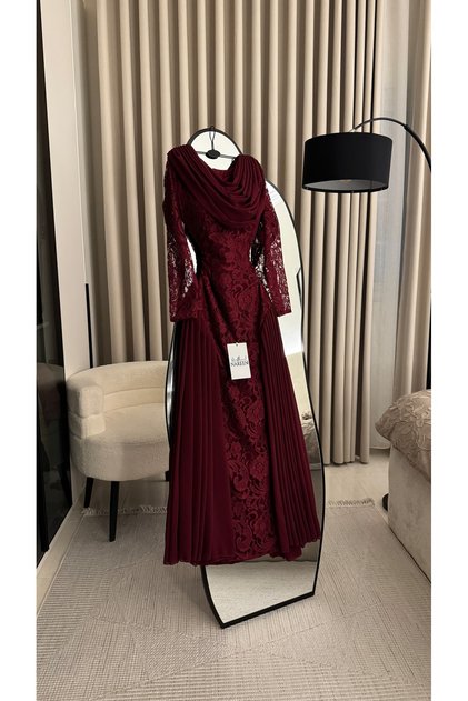 A luxurious evening gown in a deep burgundy hue that exudes elegance and sophistication. It features a distinctive design.