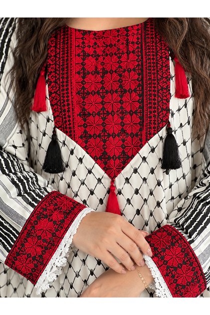 جلابية نسائية عصرية من ليالي الجلابية، تصميم مستوحى من الشماغ الفلسطيني وتطريز أحمر كثيف بشكل الفراشة