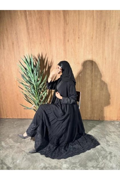 Abaya and Qamis: a Black Abaya with a Classic, High-End Design Featuring a Delicate Lace Design in the Center, Giving the Abaya a Sophisticated Feminine Touch.