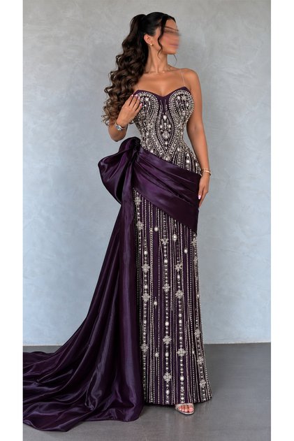 Luxurious Purple Evening Gown Featuring an Elegant Design That Combines the Sparkle of Crystal Embellishments with a Delicate Embroidered Corset and a Sweetheart Neckline, Organza Wrap Around the Waist Adorned with a Side Bow, and a Long Flowing Train.