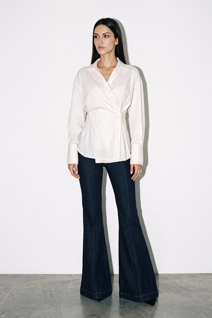 Cream 100% cotton shirt with waist detail, asymmetric closure, long sleeves, and a relaxed fit.