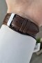 Men's wristwatch with metallic case, brown strap, and 2-year warranty. - 4