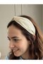 Cream-colored fabric crown with stone embellishments and knotted detailing