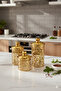 A set of three different-sized acrylic containers for storing spices, legumes, and sugar, in a gold color. - 4