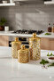 A set of three different-sized acrylic containers for storing spices, legumes, and sugar, in a gold color.