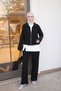طقم مكون من ثلاث قطع: جاكيت أسود بسحاب، وبنطلون.