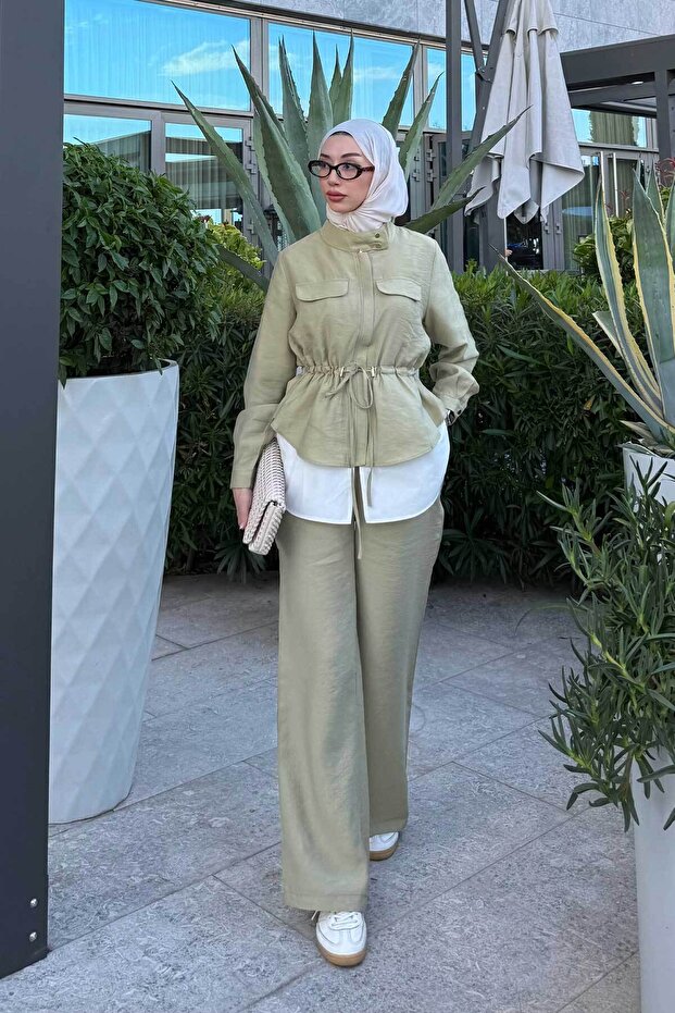 بدلة نسائية بتفاصيل جيوب مزدوجة وأزرار مخفية باللون الأخضر الفاتح