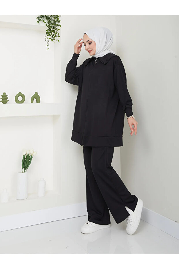 Women's modest outfit with slit hem, zipper detail, and trousers.