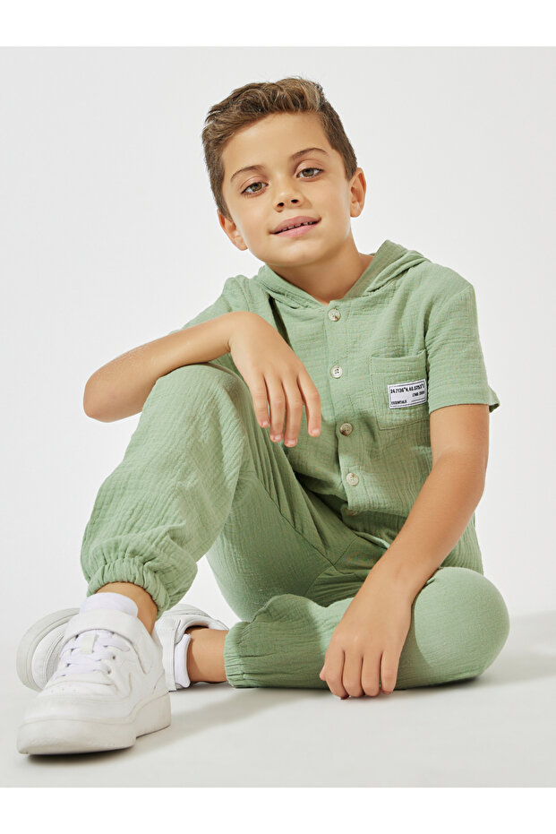 طقم من بلوزة بغطاء رأس وبنطال رياضي من نسيج سادة - 1