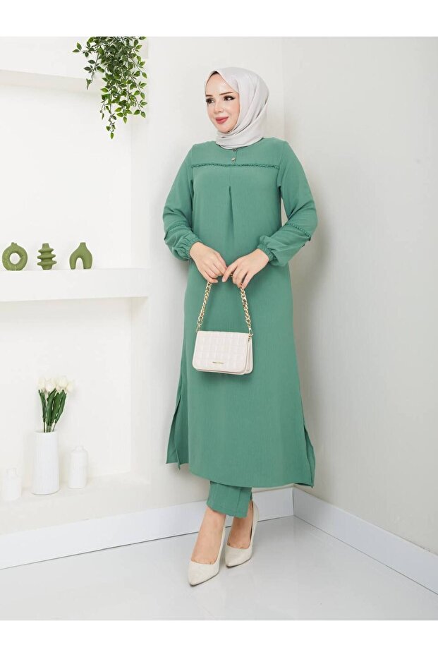Two-piece set of plus-size tunic and pants made from aerobin fabric with embroidered details on the sleeves and chest.