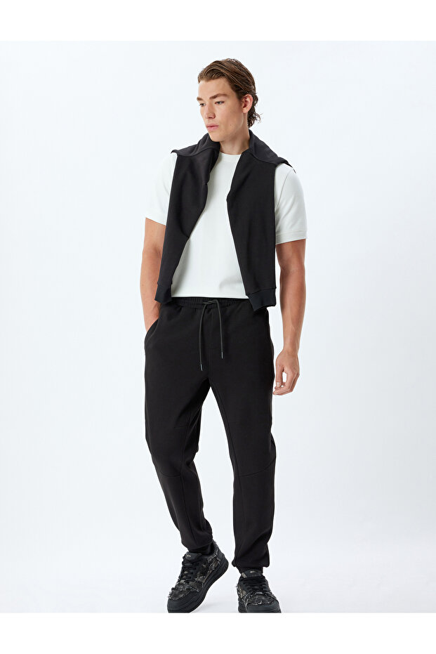 Sweatpants with Lace-Up Waist, Elastic Cuffs, Zipper Pockets, and Cotton Details.