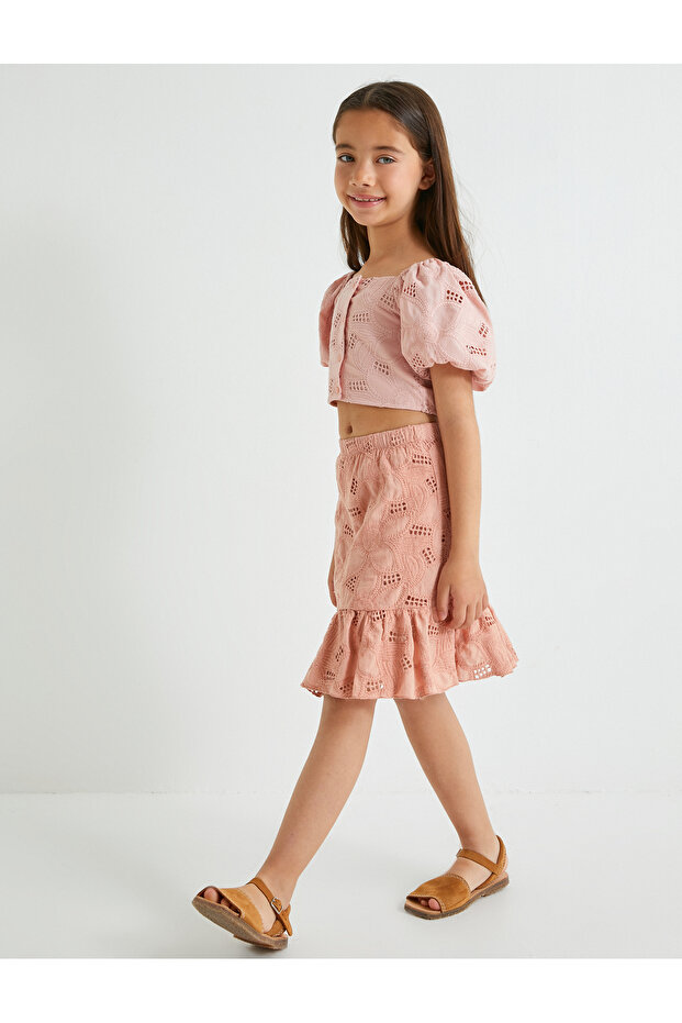 Crop blouse with button closure, scalloped detail, and balloon sleeves.