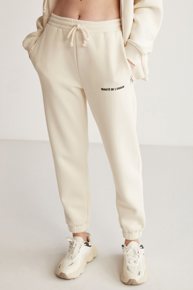 Damskie spodnie dresowe Carroline o swobodnym kroju, haftowane, waniliowe, z elastyczną talią i nogawkami - 1