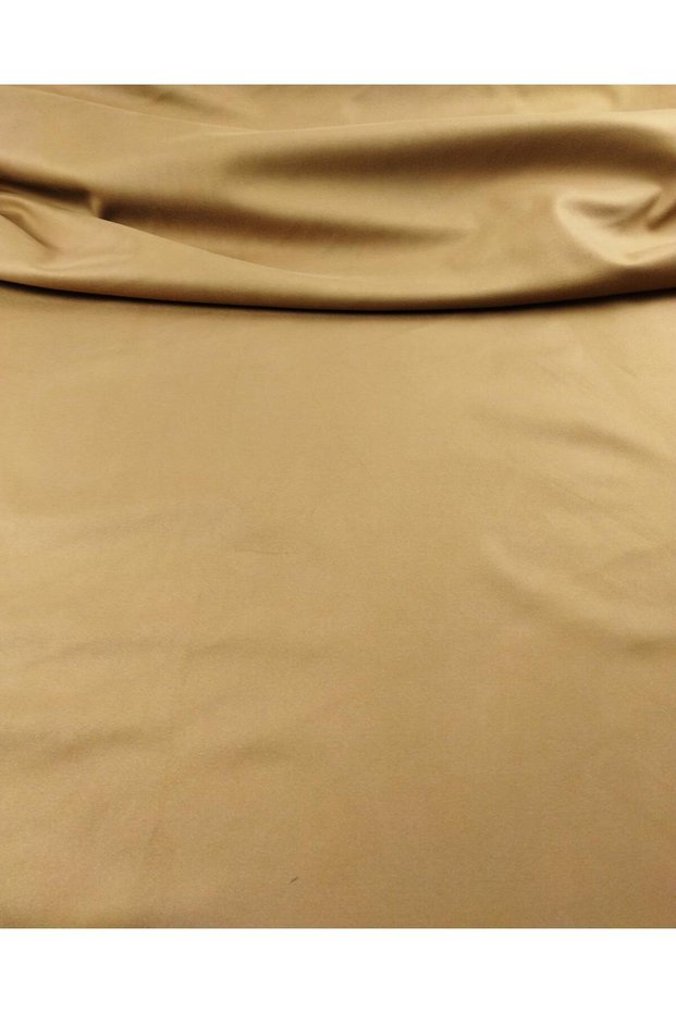 Laminated knit in tan color on black jersey fabric. Width: 150 cm