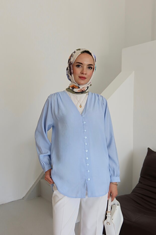 قميص بياقة على شكل حرف V وأزرار أمامية مفصلة باللون الأزرق