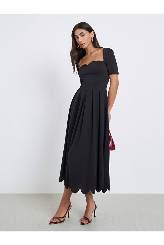 فستان أسود متوسط الطول بقصة A وحافة صدفية