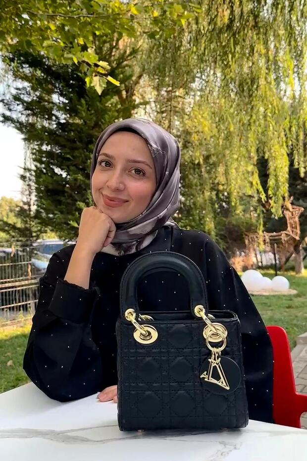 حقيبة يد مربعة باللون الأسود مع تفاصيل سلسلة ذهبية