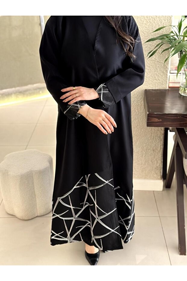 A distinctive white linen abaya with a rounded bottom and a zigzag pattern. - 1