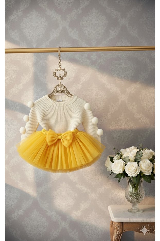 Girl's pom-pom knit sweater and yellow tutu skirt set.