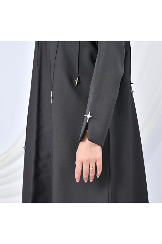 A modern design abaya in gray, adorned with gold buttons in the shape of cascading stars, adding a striking touch. - 4