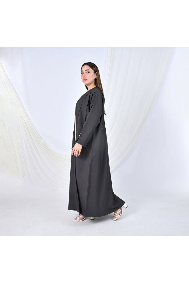 A modern design abaya in gray, adorned with gold buttons in the shape of cascading stars, adding a striking touch. - 3