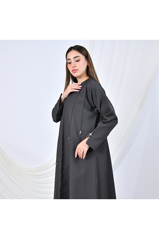 A modern design abaya in gray, adorned with gold buttons in the shape of cascading stars, adding a striking touch. - 2