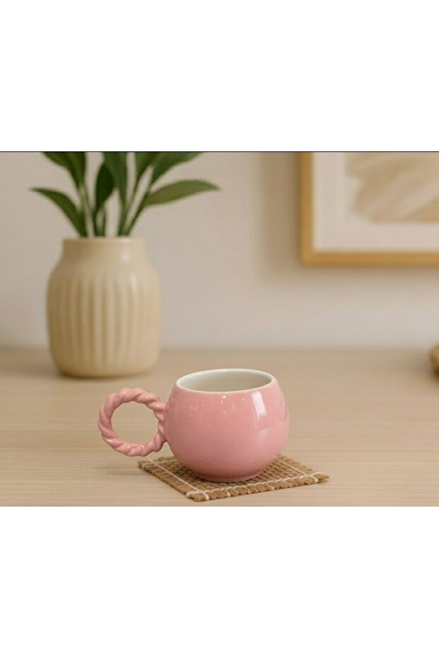 كوب سيراميك وردي اللون مع تفاصيل بيضاء داخلية، مصنوع يدويًا بتصميم خاص