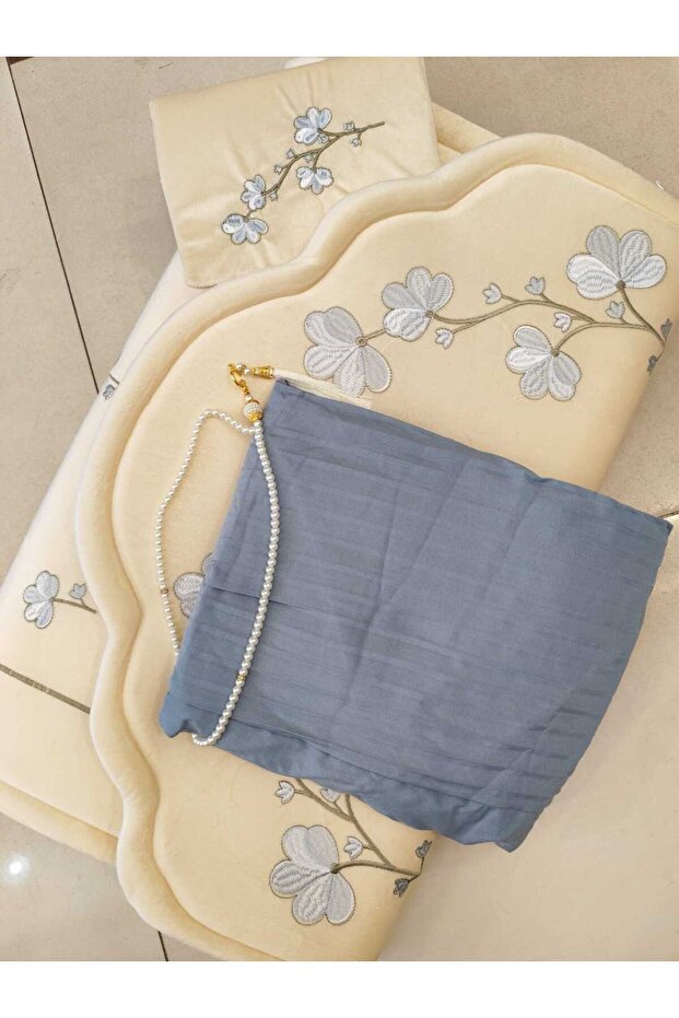 A soft prayer rug with a luxurious design, complete with a prayer mat and rosary.