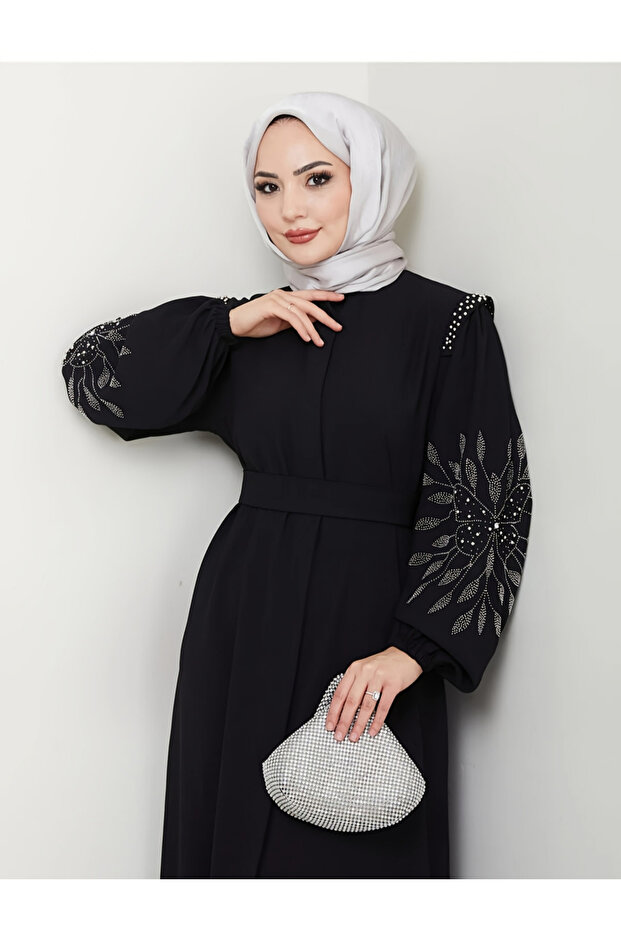مرقَّع سوداء بأكمام طويلة مزينة بتفاصيل مرقعة