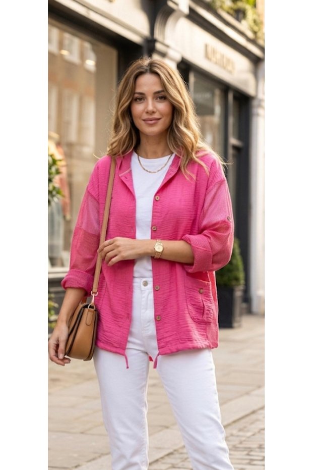 Fuchsia pink seasonal shirt with fold-over sleeves, mesh detailing on the sides, and a hooded design with linen lace-up ties.