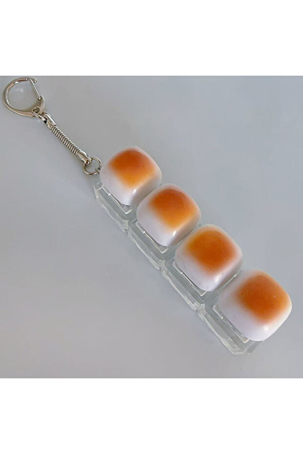 4 قطع جديدة من سلسلة مفاتيح على شكل خبز الكراميل لتخفيف التوتر، مع زر مضيء على شكل غطاء مفتاح، وقلادة للحقيبة للطلاب.