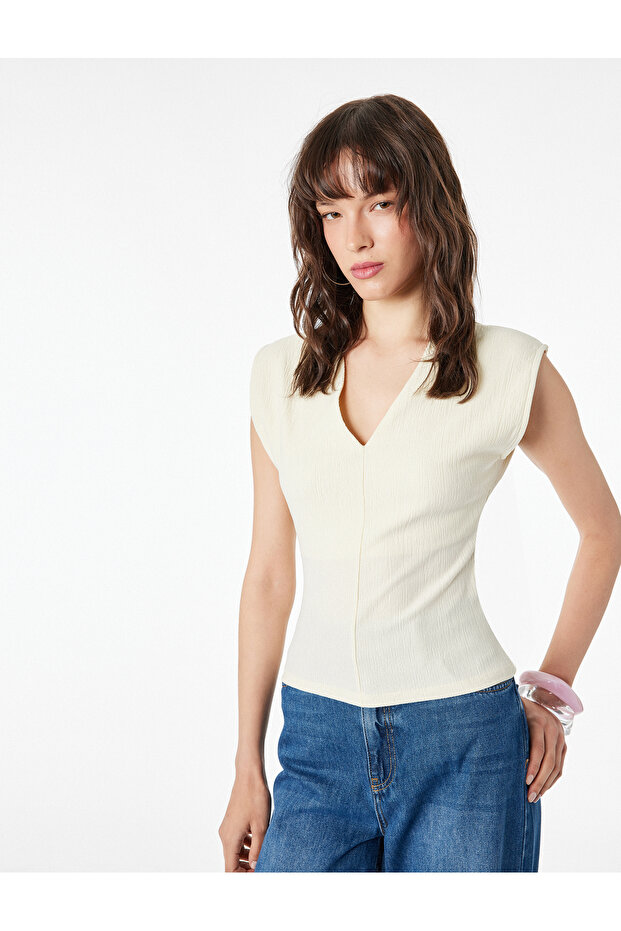 بلوزة بدون أكمام ذات ملمس مميز وقصة ضيقة وياقة على شكل حرف V