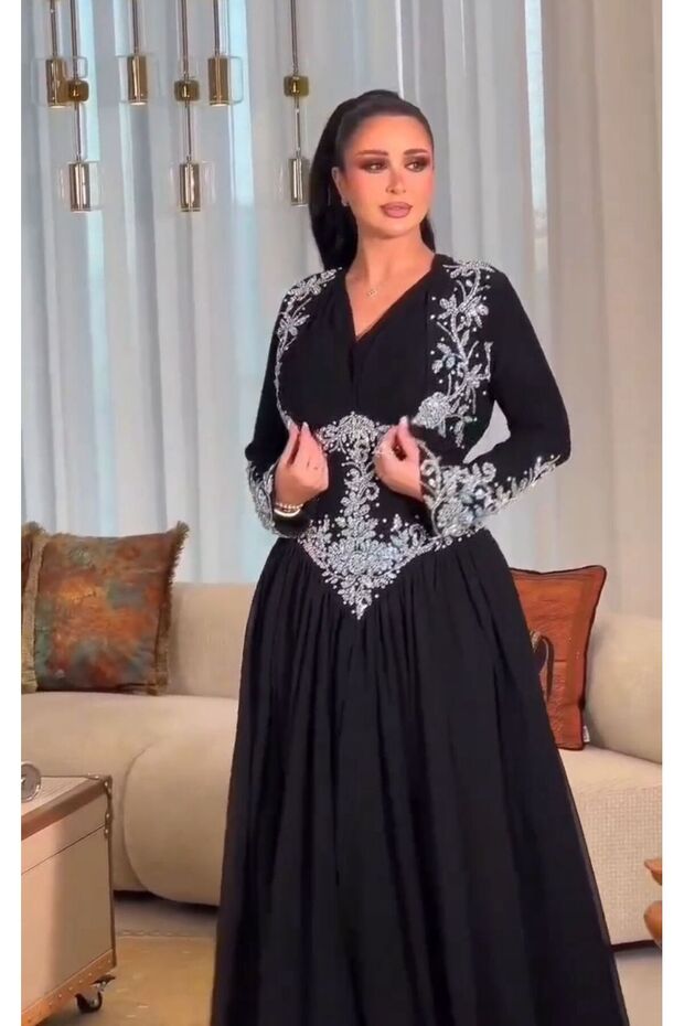 فستان سهرة أسود بتطريز فضي وأزرق، يجمع بين الفخامة الشرقية واللمسة العصرية،