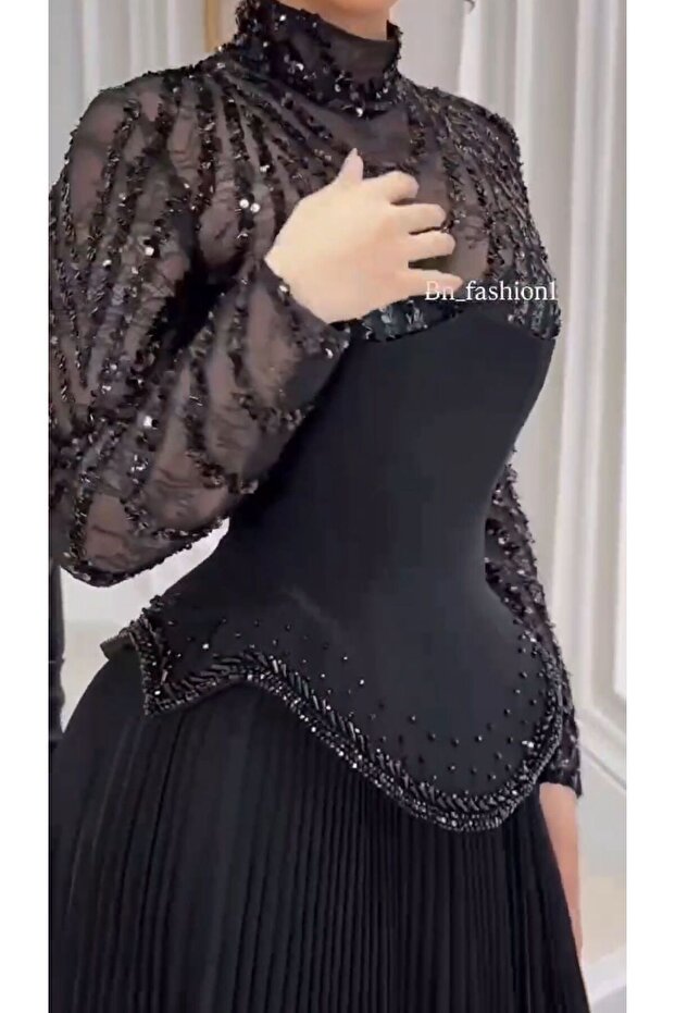فستان سهرة أسود طويل بتصميم راقٍ يجمع بين الهيبة والأنوثة