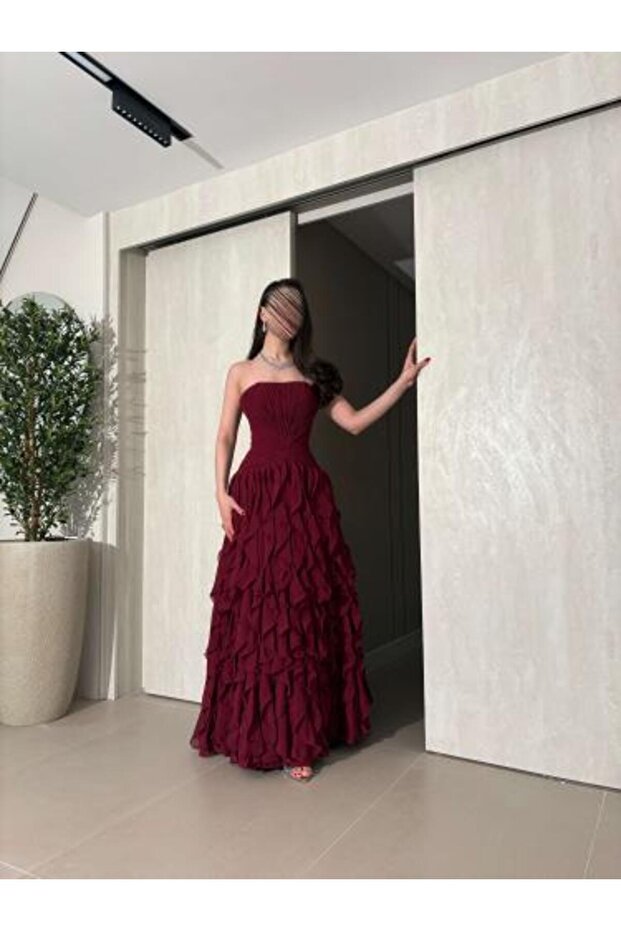 فستان سهرة فاخر بلون خمري مع طبقات كشكشة انسيابية وتصميم كورسيه.