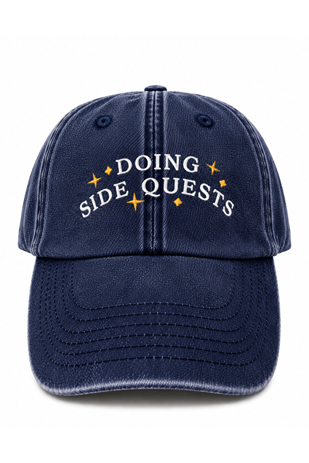 قبعة مطرزة مكتوبة عليها عبارة "Doing Side Quests (Yan Görevlerde)" قابلة للغسل بتصميم عتيق